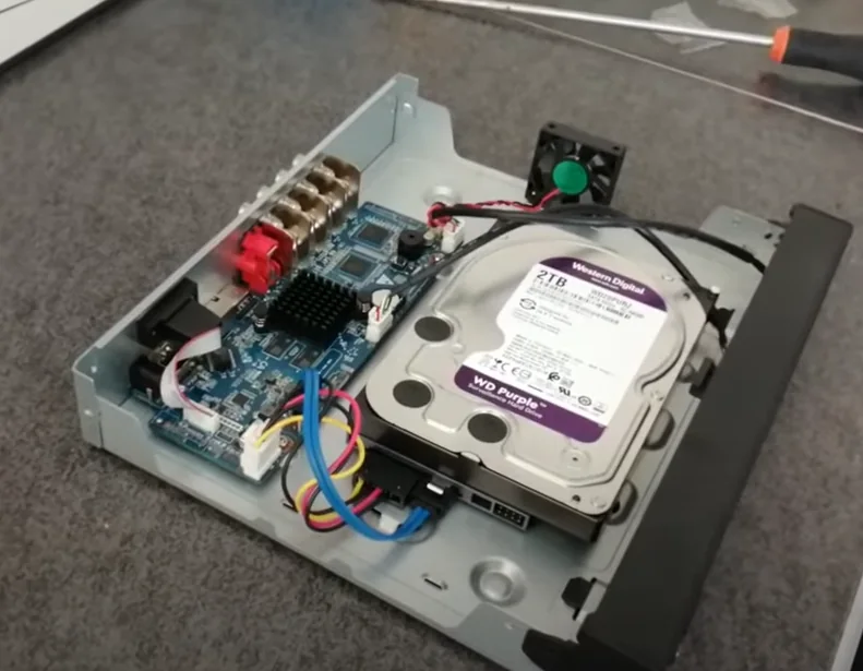 Disco duro WD Purple instalado dentro de un DVR, conectado con cables SATA y de alimentación